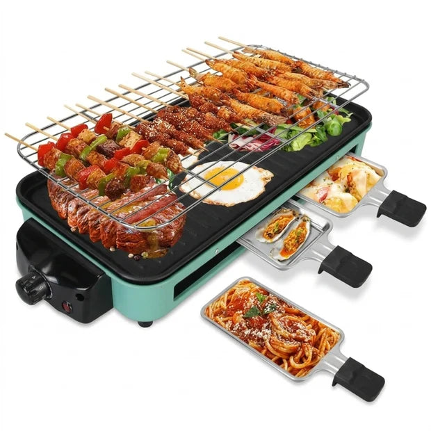 A multi-functional electric grill with a black griddle surface, a wire upper rack for skewers and kebabs, and three detachable stainless steel pans with black handles containing cooked food, shown on a white background.