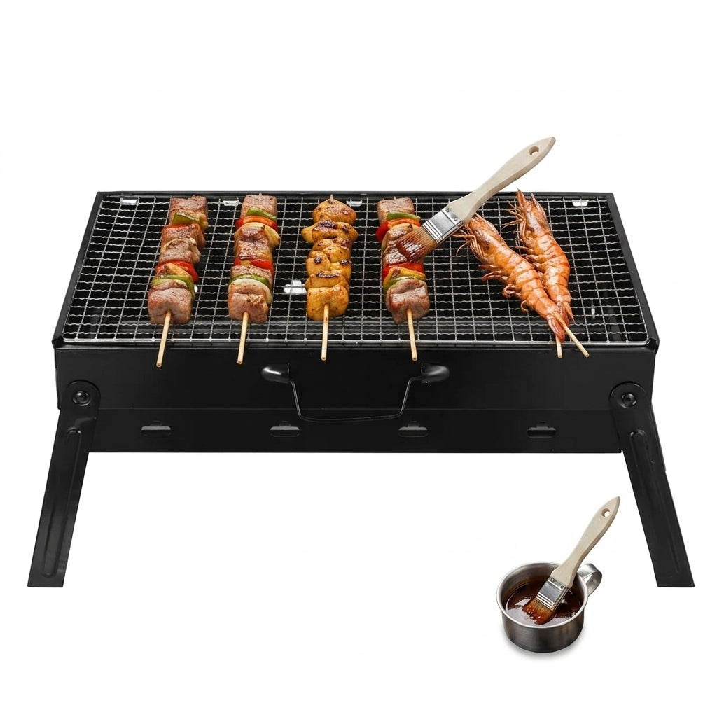A black portable folding charcoal grill with skewers of meat, vegetables, and shrimp cooking on the grate, plus a small saucepan with a brush shown below on a white background.