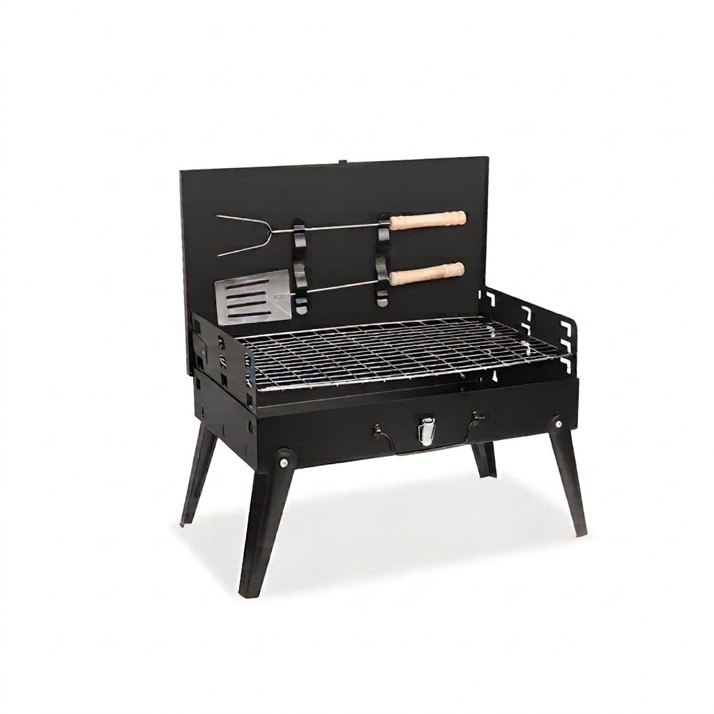 A black metal mini grill with legs, a wire grate, and a back panel holding two tools with light wood handles, shown on a white background.